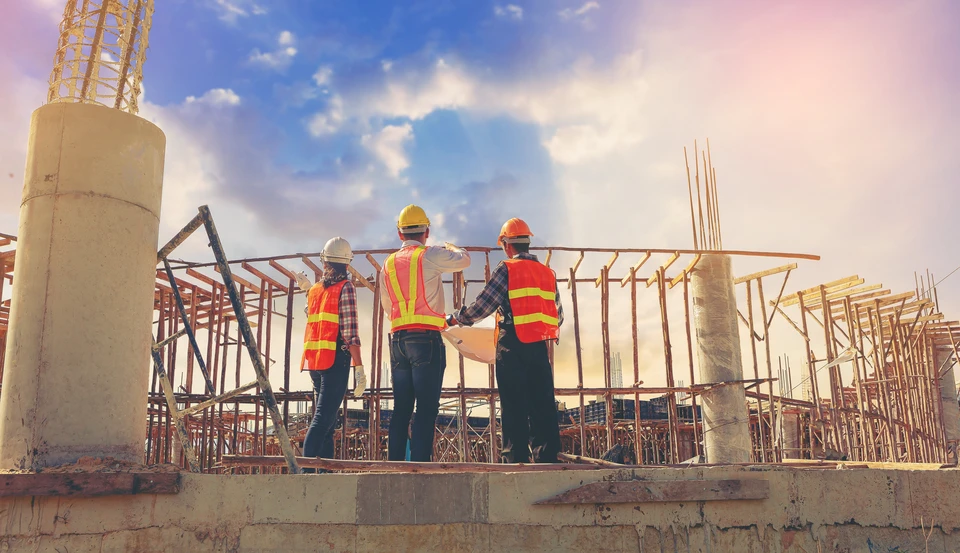 Ing&eacute;nieur de structure et architecte et contrema&icirc;tre travailleur avec des plans discutent, abonnement travaillant pour le chantier de construction en plein air