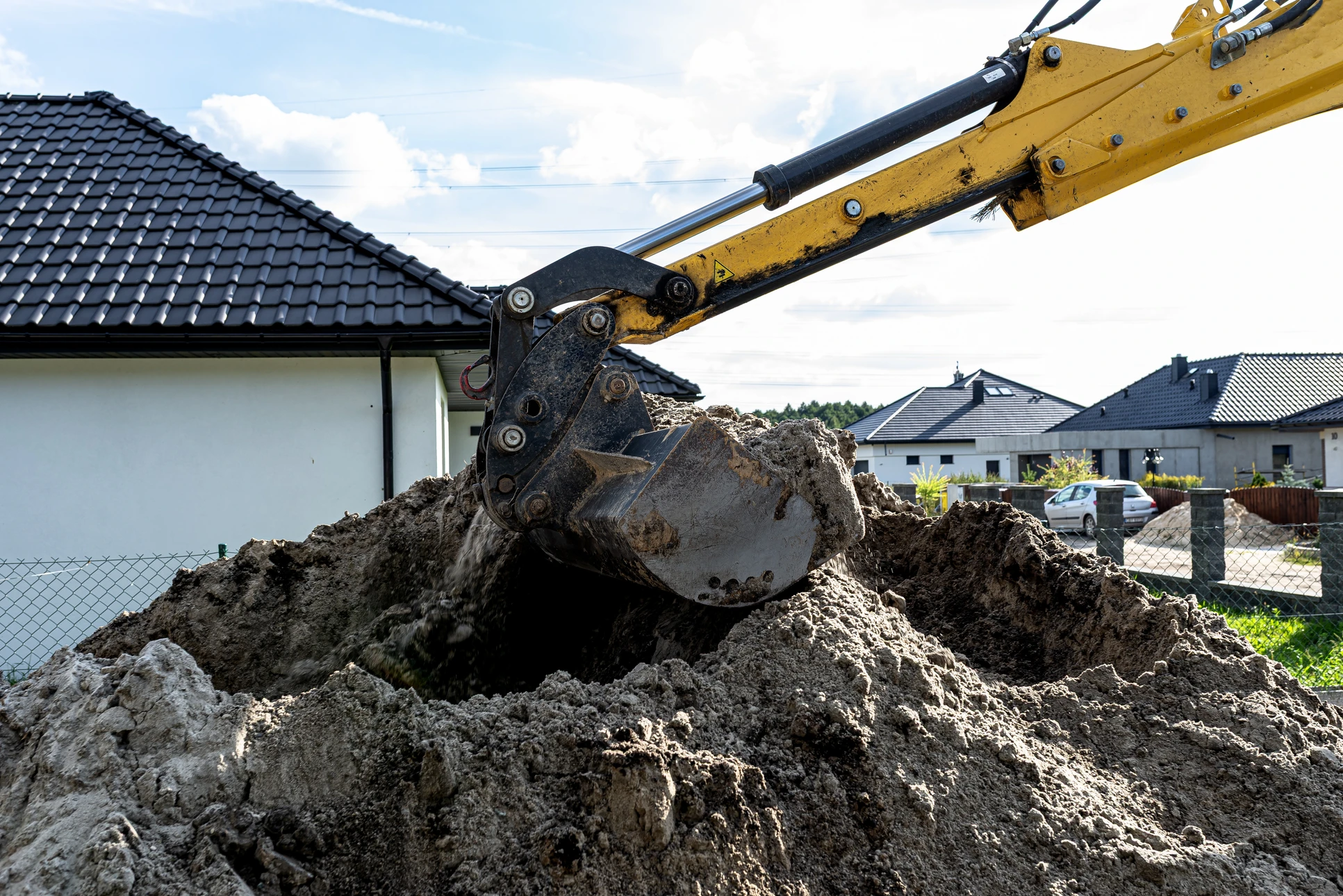 Chantier de construction ext&eacute;rieur avec pelleteuse hydraulique jaune en activit&eacute; sur terrain de terrassement